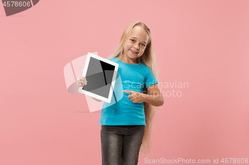 Image of Little funny girl with tablet on pink background