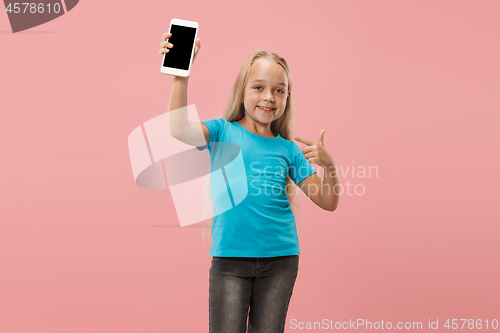 Image of The happy teen girl standing and smiling against pink background.