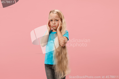 Image of Girl having headache. Isolated over pink background.