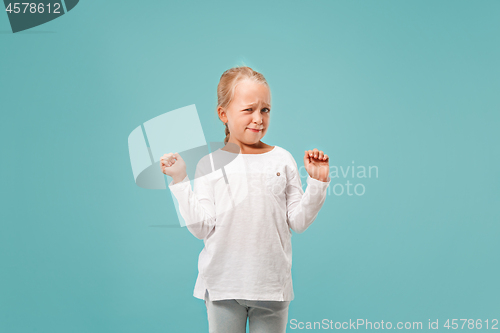 Image of Doubtful pensive teen girl rejecting something against blue background