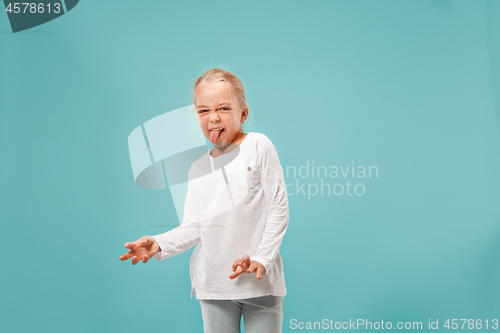 Image of Doubtful pensive teen girl rejecting something against blue background