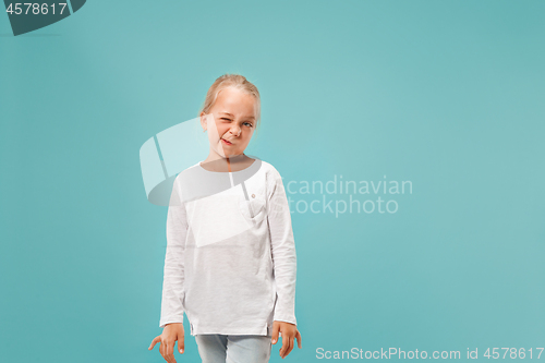 Image of Doubtful pensive teen girl rejecting something against blue background