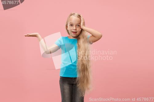 Image of The happy teen girl standing and smiling against blue background.