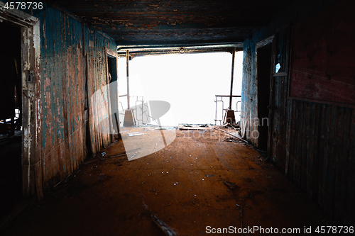 Image of An abandoned rusty corridor with light at the end