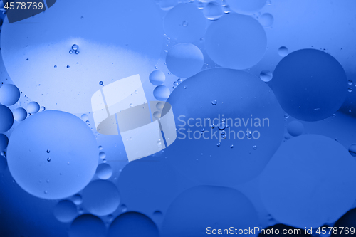 Image of Defocused abstract background picture made with oil, water and soap. Blue toned.