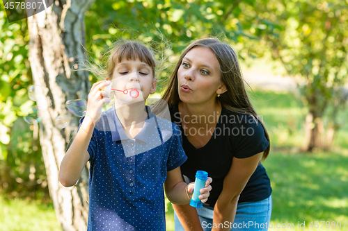 Image of Girl and girl blow bubbles together