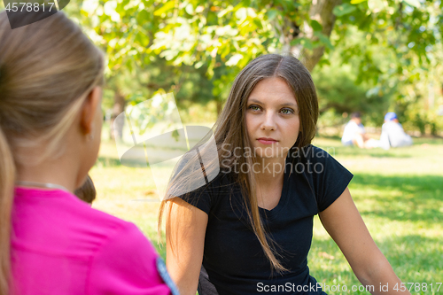 Image of The girl on a picnic listens attentively to the interlocutor