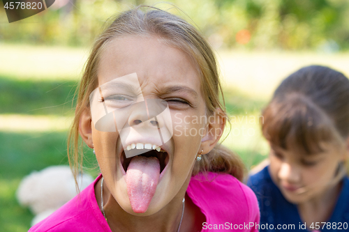 Image of The girl turned and funny shows a long tongue