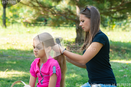 Image of Girl combing hair girl