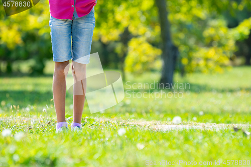 Image of Children\'s feet are on the lawn in the park. Close-up