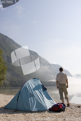 Image of Man standing at mountain lake
