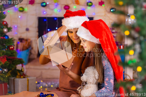 Image of Mom and girl opened the gift lid and peeked into the box