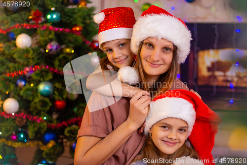 Image of Mother and two daughters at the Christmas tree