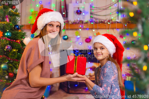 Image of Mom and daughter hold a gift and looked into the frame