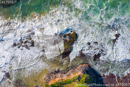 Image of Water flowing over coastal rocks and eroded rock chasms