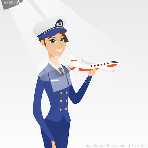 Image of Cheerful airline pilot with the model of airplane.