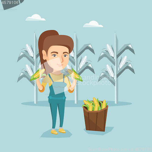 Image of Young caucasian farmer collecting corn harvest.