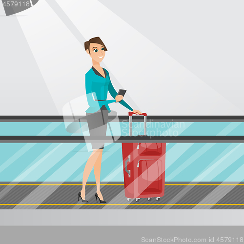 Image of Woman using smartphone on escalator at the airport