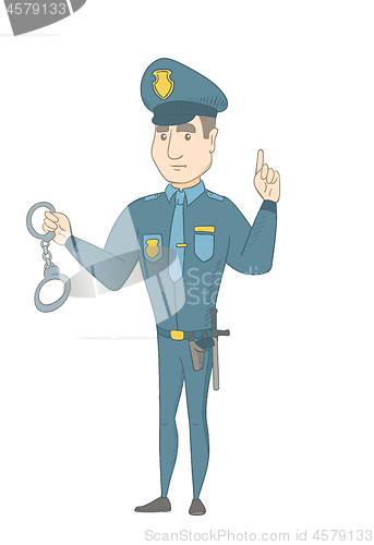 Image of Young caucasian policeman holding handcuffs.