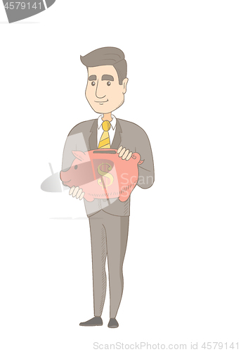 Image of Young caucasian businessman holding a piggy bank.