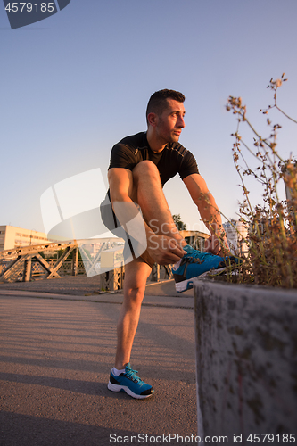 Image of man tying running shoes laces