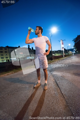 Image of man drinking water after running session