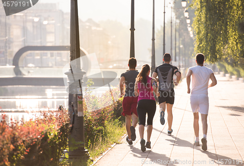 Image of group of young people jogging in the city