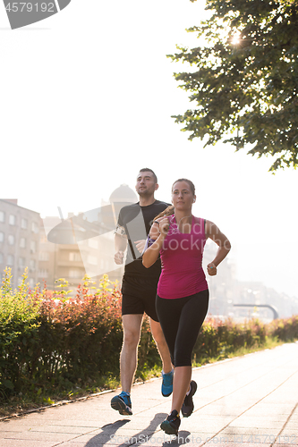 Image of young couple jogging  in the city