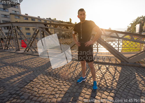 Image of portrait of a jogging man at sunny morning