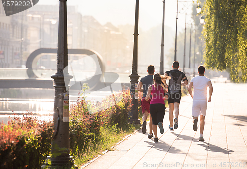 Image of group of young people jogging in the city