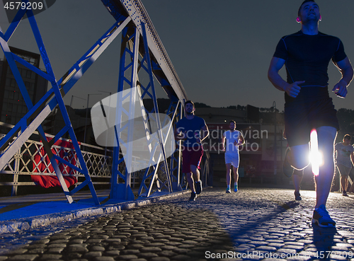 Image of young people jogging across the bridge