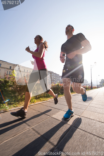 Image of young couple jogging  in the city