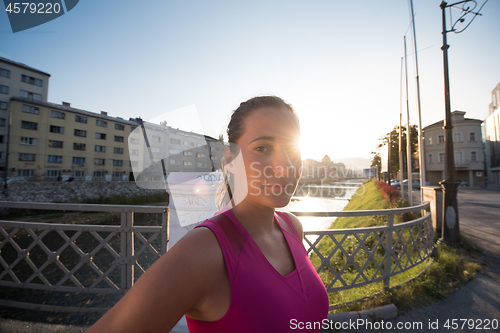 Image of portrait of a jogging woman at sunny morning