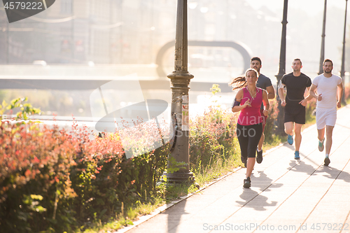 Image of group of young people jogging in the city