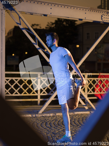 Image of man jogging across the bridge in the city