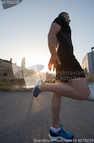 Image of athlete man warming up and stretching