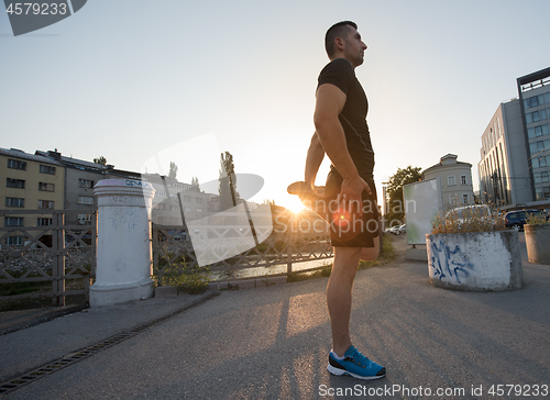 Image of athlete man warming up and stretching