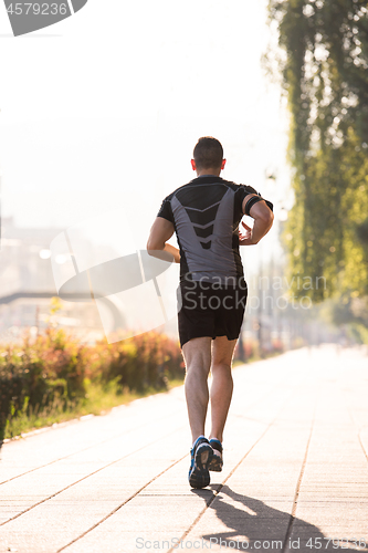 Image of man jogging at sunny morning