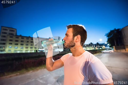 Image of man drinking water after running session