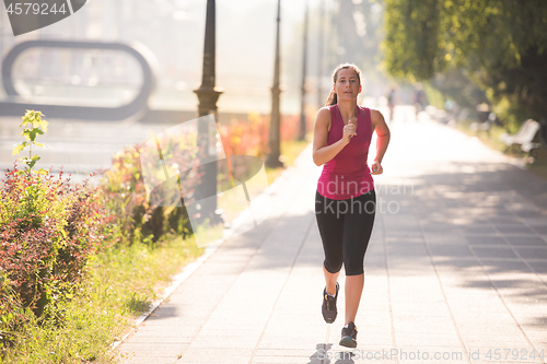 Image of woman jogging at sunny morning