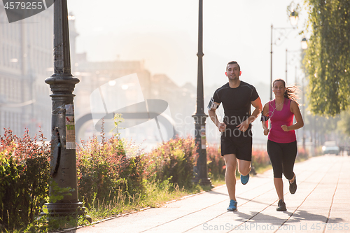 Image of young couple jogging  in the city