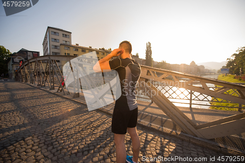 Image of portrait of a jogging man at sunny morning