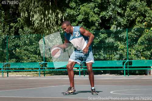 Image of Picture of young confused african basketball player practicing