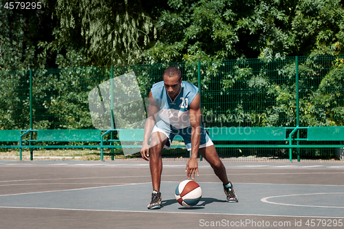 Image of Picture of young confused african basketball player practicing