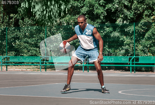 Image of Picture of young confused african basketball player practicing