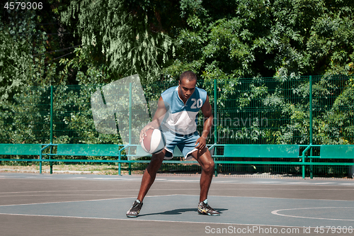 Image of Picture of young confused african basketball player practicing