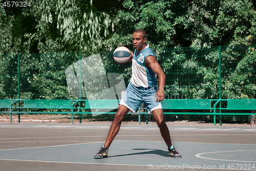 Image of Picture of young confused african basketball player practicing