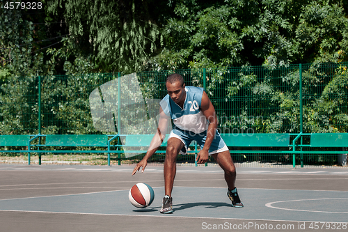 Image of Picture of young confused african basketball player practicing