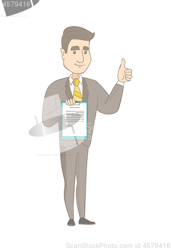 Image of Young businessman showing clipboard and thumb up.
