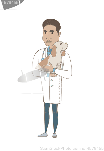Image of Young hispanic veterinarian with dog in hands.